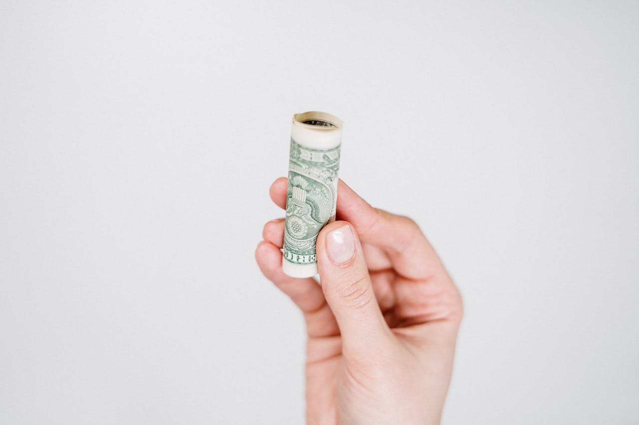 person holding rolled up bill